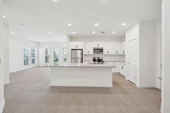 A spacious kitchen with white cabinets and a central island.
